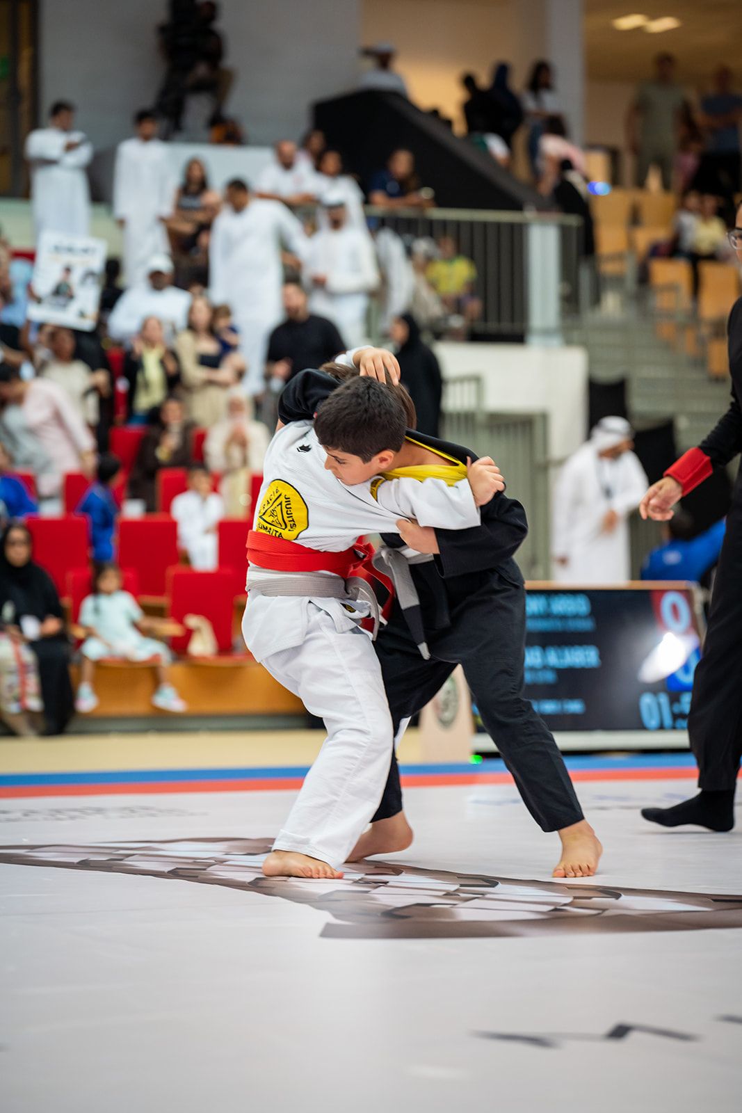 Two young grapplers battling for grips during a Jiu-Jitsu match